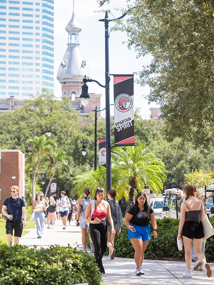 Students walking on campus with downtown Tampa in the background.